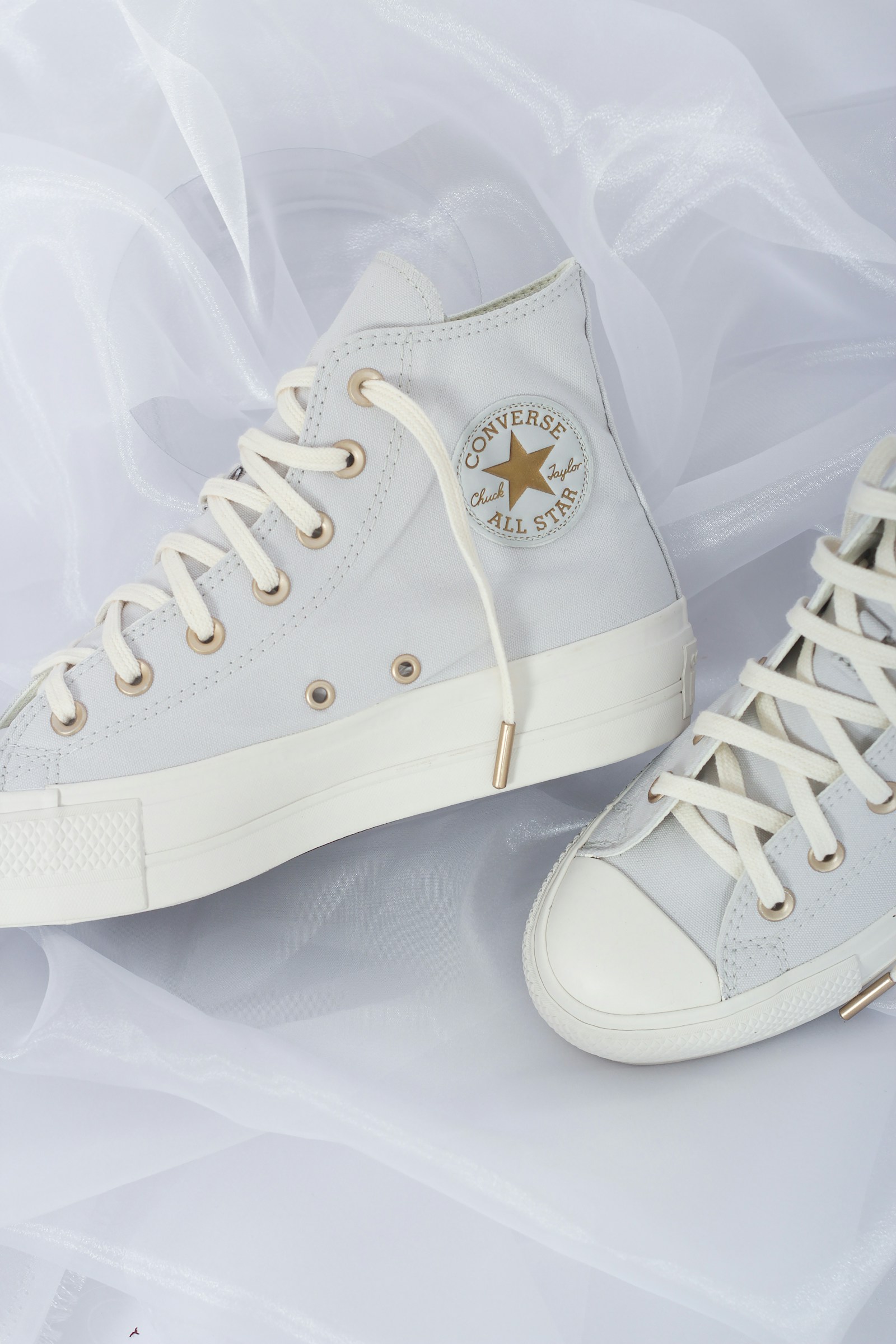 Luxury white high-top sneakers on soft white fabric